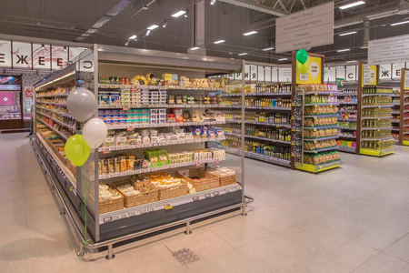 Торговый зал супермаркета «Перекрёсток», где на первом плане изображен стеллаж с сырами, а на заднем фоне стеллаж с растительными маслами.